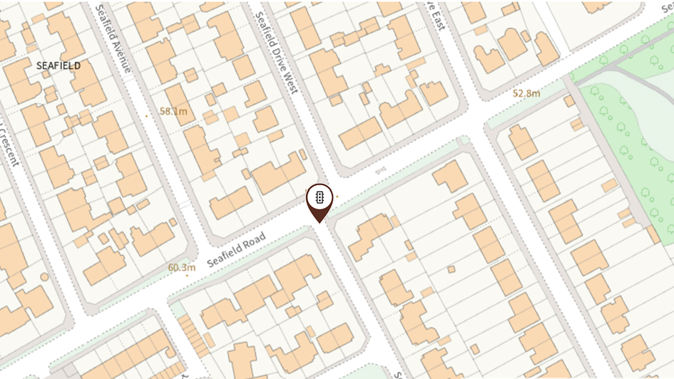 Street map of Seafield Road showing a location pin amid residential buildings, intersecting streets, labeled elevations, and a green park area.
